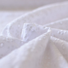 Tissu broderie anglaise sur voile de coton blanc à coudre