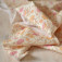 Tissu imprimé fleurs indiennes orange et rose sur écru en coton Bio